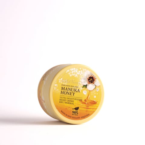 Round jar of Manuka Honey ultra moisturizing skin cream with yellow label and white background