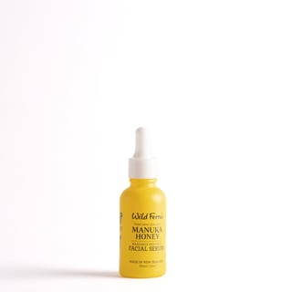Yellow bottle of Wild Ferns Manuka Honey facial serum with white dropper cap on white background