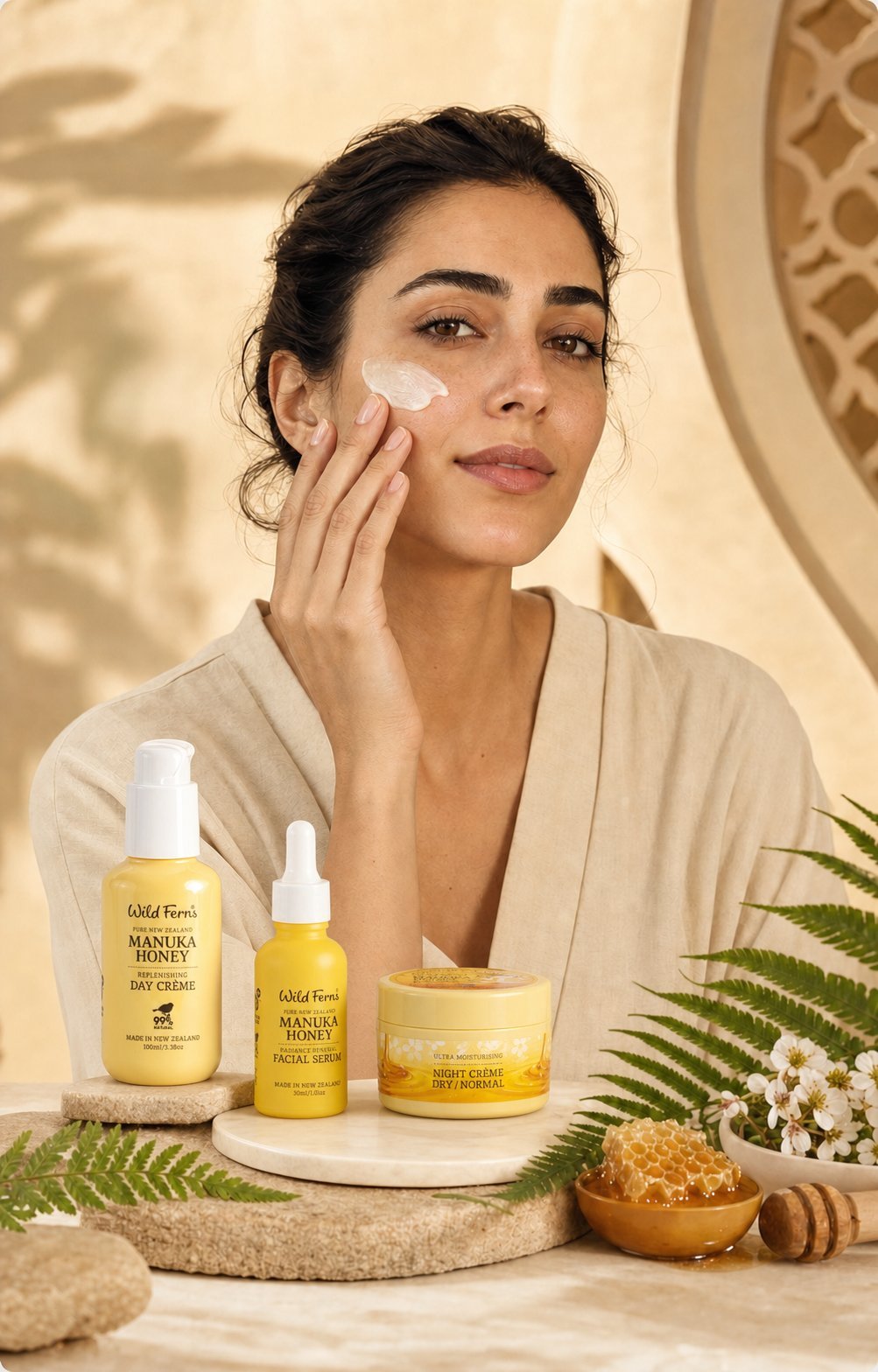 Woman applying skincare cream to face surrounded by manuka honey beauty products and natural ingredients